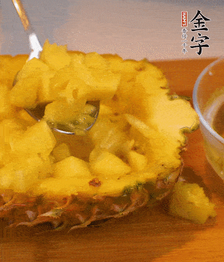 菠蘿對(duì)半切開(kāi)，切成小方格，用勺子把菠蘿肉挖出來(lái)。用鹽水稍浸泡。