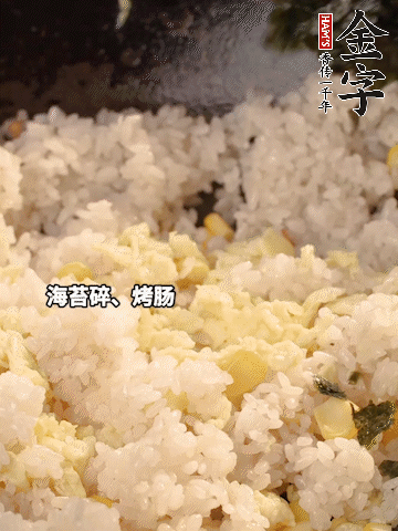 剩米飯下鍋炒散，依次下玉米粒、雞蛋、烤腸、海苔碎翻炒均勻。