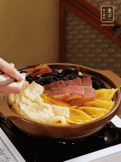 砂鍋底部鋪上娃娃菜，依次擺上肉皮、蛋餃、黑木耳、火腿